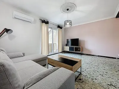a living room with a couch and a tv at Le Cassayet - Appartement proche des Grands Buffets - Wifi et Climatisation in Narbonne
