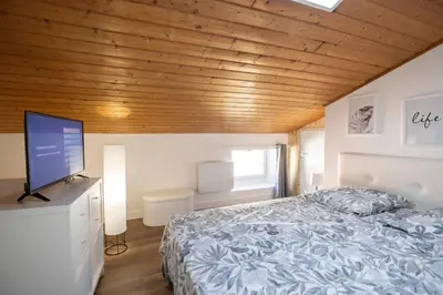 a bedroom with a bed and a flat screen tv at Duplex cosy à Mirepoix centre, tout confort in Mirepoix