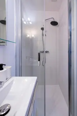 a white bathroom with a shower and a sink at 2 appartements cosys en plein cœur de Varilhes in Varilhes