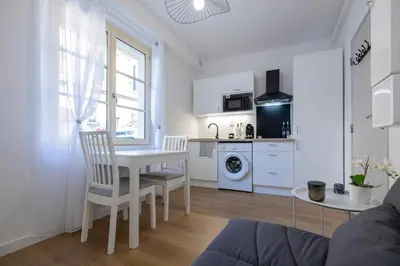 a kitchen and living room with a table and chairs at 2 appartements cosys en plein cœur de Varilhes in Varilhes