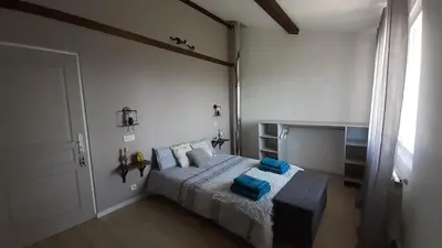 a bedroom with a bed with blue pillows on it at Les chambres de Guillaunas Haut in Saint-Germain-des-Prés
