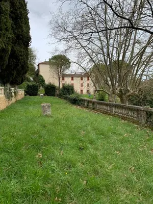 a field of grass with a building in the background at Domaine de Grave in Mirepoix
