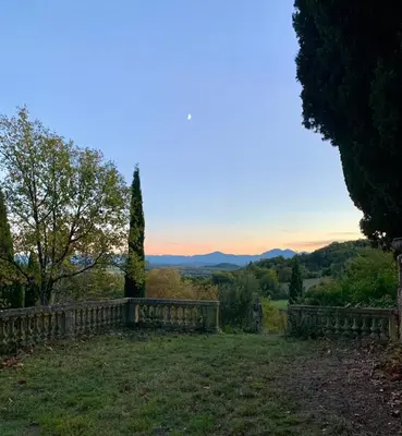 a fence in a field with a view of the mountains at Domaine de Grave in Mirepoix