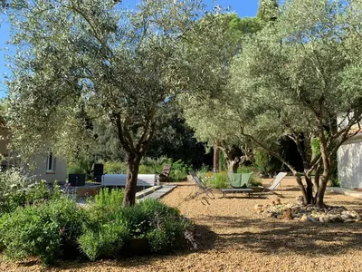 a garden with trees and benches in a yard at Domaine de Grave in Mirepoix