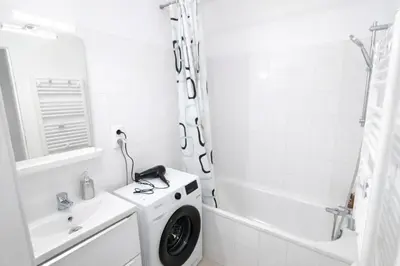 a white bathroom with a washing machine in a sink at T2 lumineux avec parking privé in Narbonne