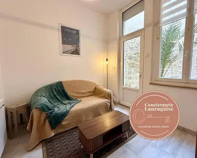 a bedroom with a bed and a table and a window at L'Atrium - Cour intérieure & box vélo, rdc in Castelnaudary