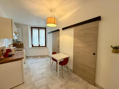 a kitchen with a table and a door with a table and chairs at L'Atrium - Cour intérieure & box vélo, rdc in Castelnaudary
