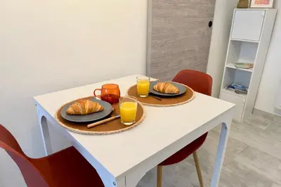 a table with two plates of food and glasses of orange juice at L'Atrium - Cour intérieure & box vélo, rdc in Castelnaudary