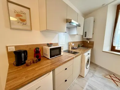 a kitchen with a counter top with a microwave at L'Atrium - Cour intérieure & box vélo, rdc in Castelnaudary