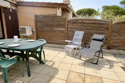 a patio with a table and chairs on a patio at Pavillon avec grande terrasse à l'abri des regard, piscine, clim - GN020-008 in Gruissan