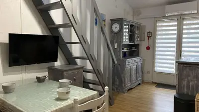 a living room with a staircase with a tv at Pavillon avec grande terrasse à l'abri des regard, piscine, clim - GN020-008 in Gruissan