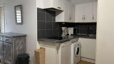 a kitchen with white cabinets and a washer at Pavillon avec grande terrasse à l'abri des regard, piscine, clim - GN020-008 in Gruissan