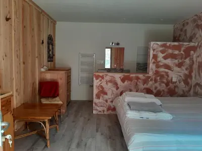a bedroom with a bed and a table and a chair at Le Rucher d'Ange in Quillan