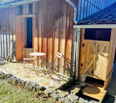 a small patio with a table and chairs next to a building at Le Rucher d'Ange in Quillan