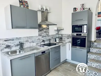 a kitchen with a sink and a stove top oven at La ceriseraie in Trausse