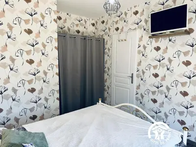 a bedroom with a bed and a tv on a wall at La ceriseraie in Trausse