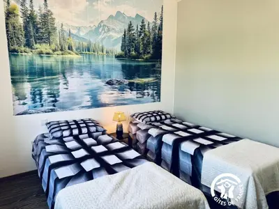 two beds in a room with a painting on the wall at La ceriseraie in Trausse