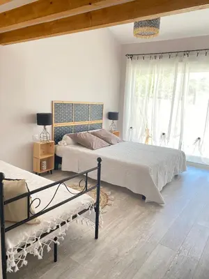 a bedroom with two beds and two windows at Entre Pins et Romarins in Bizanet