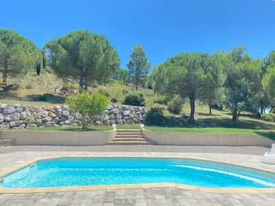 a swimming pool in a yard with trees in the background at Entre Pins et Romarins in Bizanet