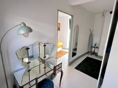 a mirror and a chair in a room at Le Nid de l'Abbaye - Maison de charme rénovée in Saint-Hilaire