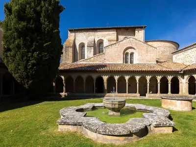 a large building with a fountain in the yard at Le Nid de l'Abbaye - Maison de charme rénovée in Saint-Hilaire