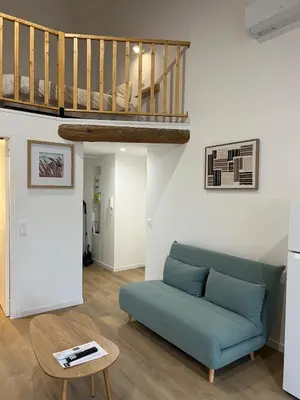 a staircase in a living room with a blue couch at L'Appart cosy 52m2 avec local à vélo près du Canal du Midi in Capestang