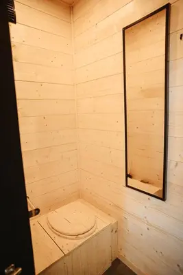 a wooden sauna with a toilet in the corner at Homnest - Brumes des Hauts Bains - Coeur Pyrennees in Escouloubre