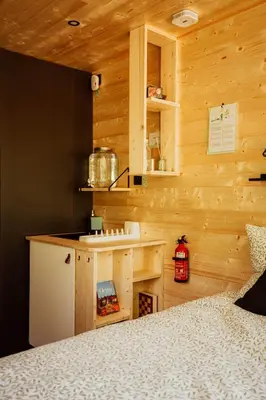 a bedroom with wooden walls and a bed in a room at Homnest - Brumes des Hauts Bains - Coeur Pyrennees in Escouloubre