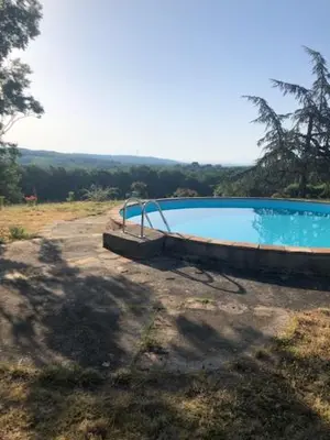 an empty swimming pool in a field with a tree at appartement, deux chambres in Damiatte