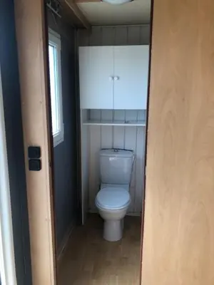a bathroom with a white toilet in a room at appartement, deux chambres in Damiatte