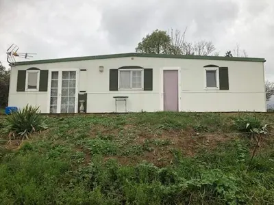 a white house with a pink door in a yard at appartement, deux chambres in Damiatte