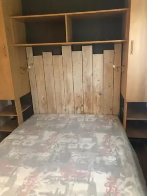a bedroom with a bed with wooden shelves at appartement, deux chambres in Damiatte