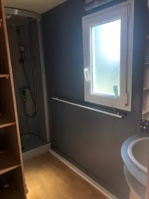 a bathroom with a shower and a sink and a window at appartement, deux chambres in Damiatte