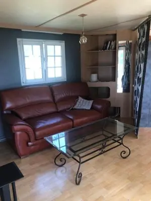 a living room with a leather couch and a glass table at appartement, deux chambres in Damiatte
