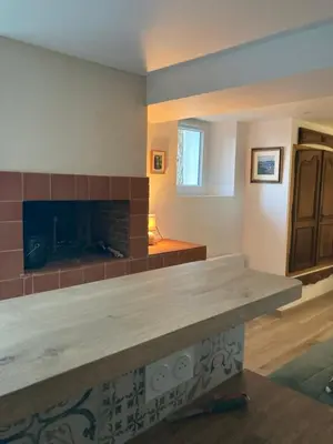 a living room with a fireplace and a table at Charmant studio avec vue sur le château de Montségur in Montferrier
