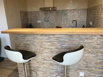 two white bar stools sitting next to a counter at Charmant studio avec vue sur le château de Montségur in Montferrier