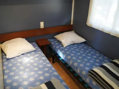two twin beds in a room with a window at Mobil-home avec Terrasse pour 4 pers. - API-1-52-1601 in Sournia