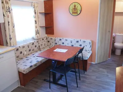 a dining room with a bench and a table at Mobil-Home avec Terrasse pour 4 pers. - API-1-52-1600 in Sournia