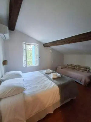 a bedroom with a large white bed and a window at Mediterranean Haven In Pine Forest At Leucate in Roquefort-des-Corbières