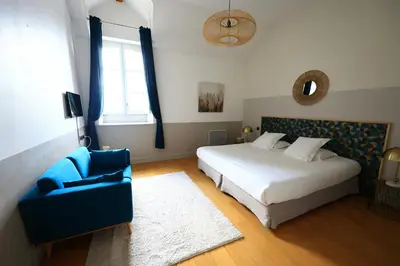 a bedroom with a bed and a blue chair at Old Hotel Reborn As An Elegant Getaway With Pool in Garrevaques