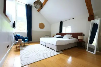 a bedroom with a white bed and a blue chair at Old Hotel Reborn As An Elegant Getaway With Pool in Garrevaques