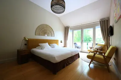 a bedroom with a bed and a chair and a window at Old Hotel Reborn As An Elegant Getaway With Pool in Garrevaques