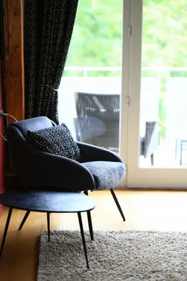 a chair sitting in a living room with a window at Old Hotel Reborn As An Elegant Getaway With Pool in Garrevaques