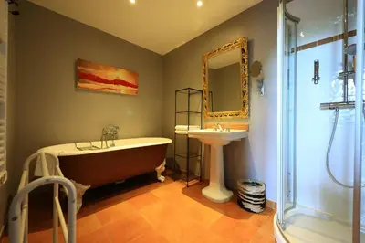 a bathroom with a bath tub and a sink at Old Hotel Reborn As An Elegant Getaway With Pool in Garrevaques