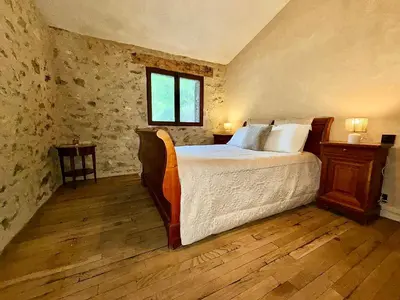 a bedroom with a large bed and a window at Farmhouse With Cathedral Lounge And Sauna In Pines in Cases-de-Pène