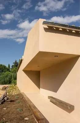 a beige building with a large opening on the side at Accessible Villa In The Heart Of Corbières in Marcorignan