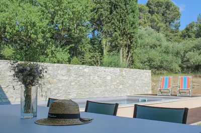 a table with a hat on top of it with chairs at Accessible Villa In The Heart Of Corbières in Marcorignan