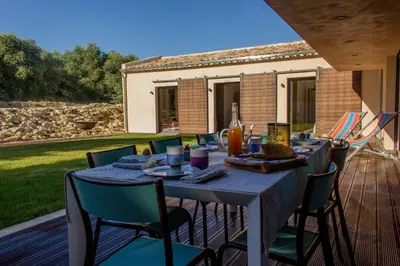 a blue table with chairs on a wooden deck at Accessible Villa In The Heart Of Corbières in Marcorignan