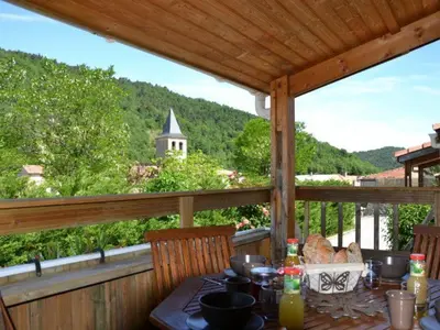 a table on a porch with a view of a mountain at Chalet PMR avec Terrasse pour 4 Pers, Roquefeuil - API-1-52-139 in Roquefeuil