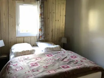 a bedroom with a bed with a blanket on it at Chalet PMR avec Terrasse pour 4 Pers, Roquefeuil - API-1-52-139 in Roquefeuil